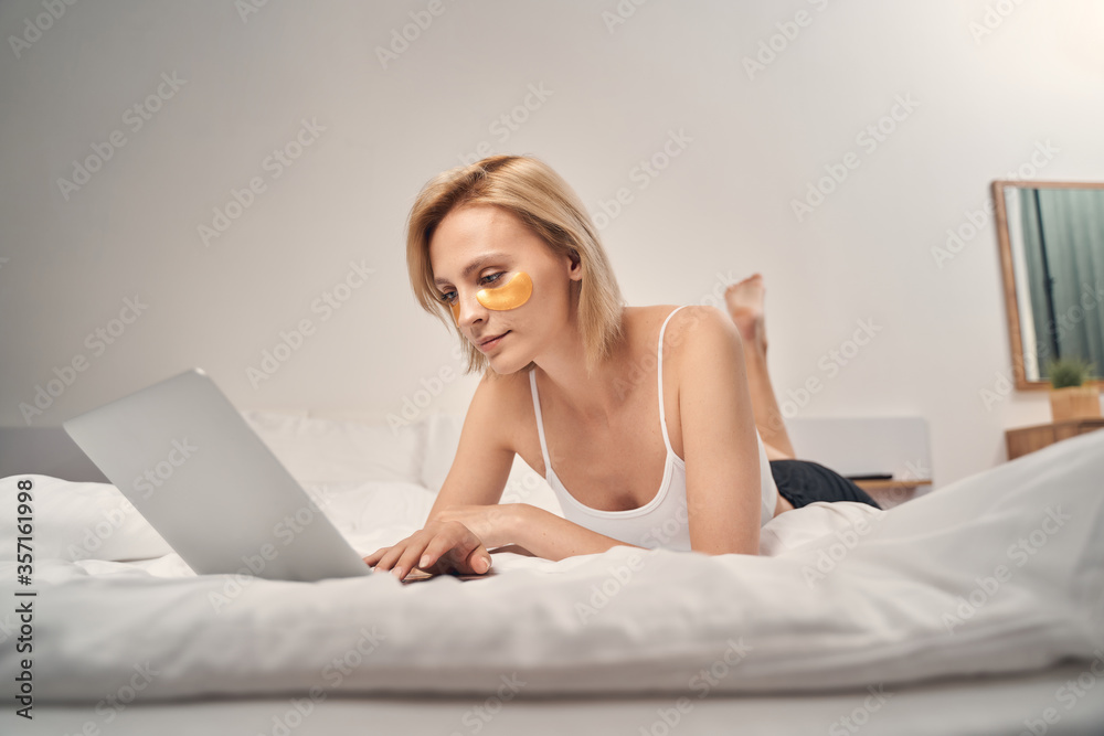 Focused woman checking her email in bed