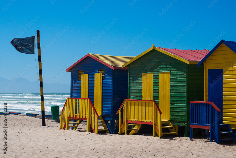 Colorful beach houses and blue sky in Muizenberg Beach in South Africa. Multi-colored beach huts in Western Cape. Shark bay. Colorful beach houses and blue sky in Muizenberg Beach in South Africa. Multi-colored beach huts in Western Cape. Shark bay.