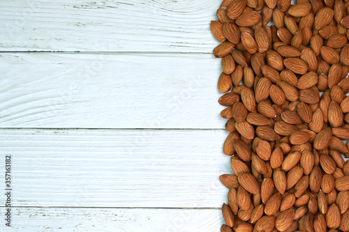 Almonds on a white wooden floor are perfect for a bright and beautiful breakfast.