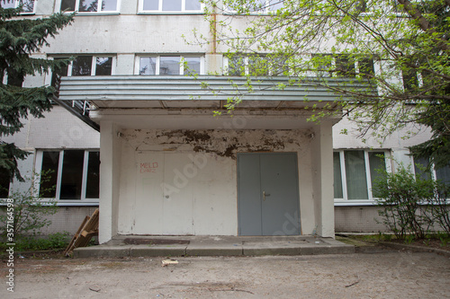 Entrance to the building in the trees, an old brutal building