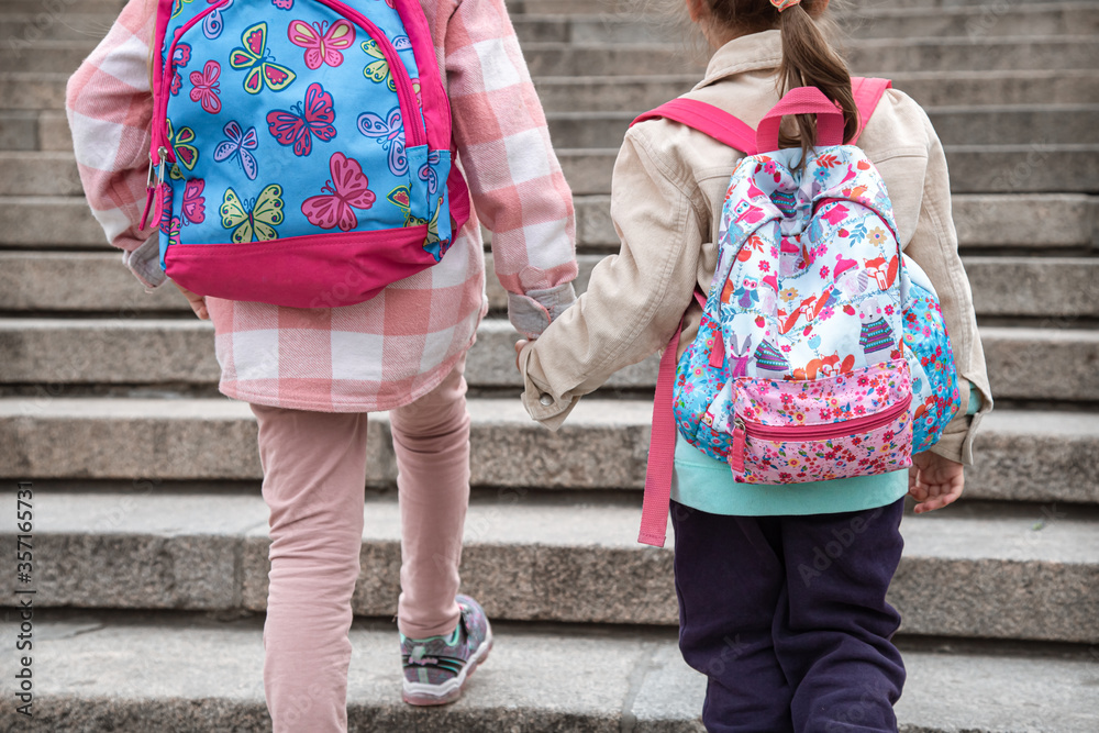 Αυτοκόλλητο Back to school, Two girls hold hands and go to school.