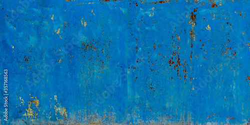 Texture, old metal gate painted with blue peeling paint with spots of rust