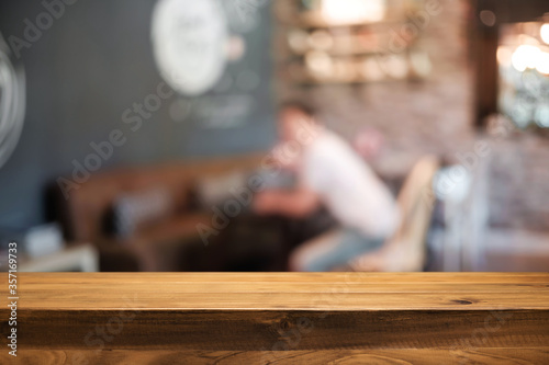 Empty wooden table space platform and blurred restaurant or coffee shop background for product display montage.