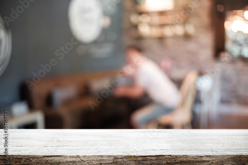 Empty wooden table space platform and blurred restaurant or coffee shop background for product display montage.