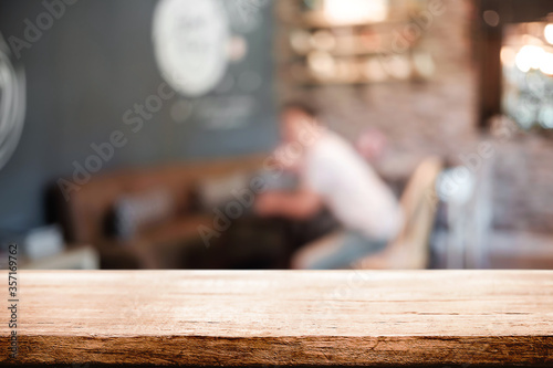 Empty wooden table space platform and blurred restaurant or coffee shop background for product display montage.