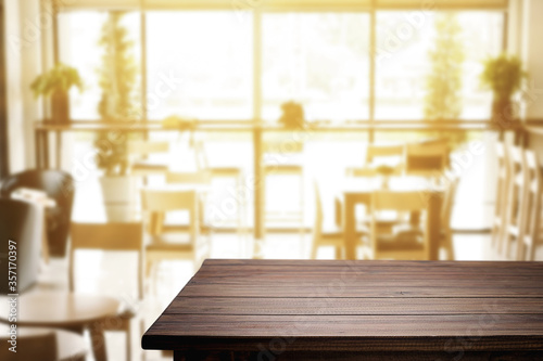 Empty wooden table space platform and blurred resturant or coffee shop background for product display montage.