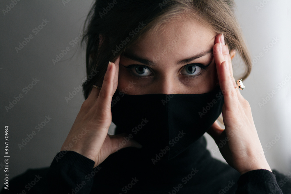 portrait of young beautiful woman in protective black stylish mask with hand on head, lifestyle 2020 under quarantine and epidemic, fashion disease, emotional shock portrait of young beautiful woman in protective black stylish mask with hand on head, lifestyle 2020 under quarantine and epidemic, fashion disease, emotional shock