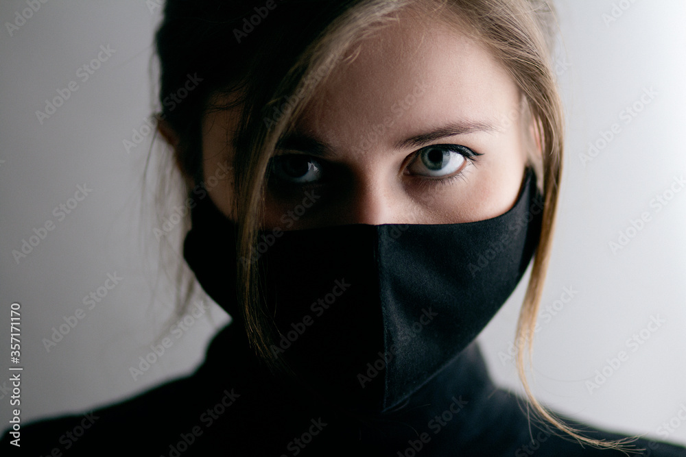 portrait of young beautiful confident woman in protective black looking feral , concept health and epidemic fashion portrait of young beautiful confident woman in protective black looking feral , concept health and epidemic fashion