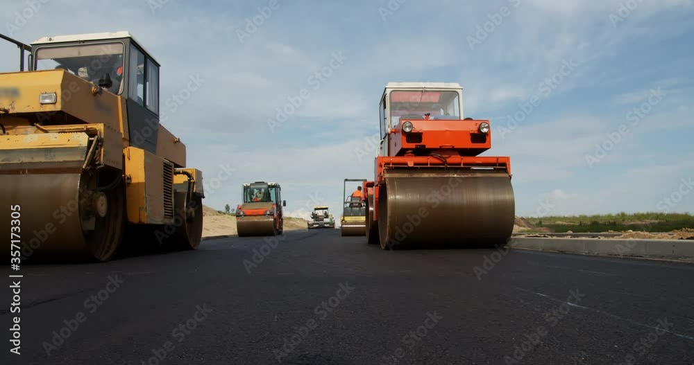 Four Pavers Ride and Flatten the Hot Asphalt Stock ビデオ Adobe Stock