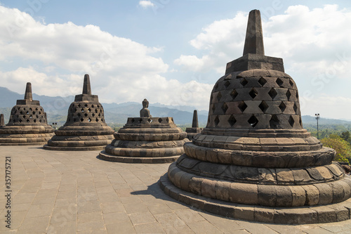Top of the empty Borobudur Buddhist temple in Central Java  Indonesia with its characteristic rhombus stupas on a hot  light-filled day.