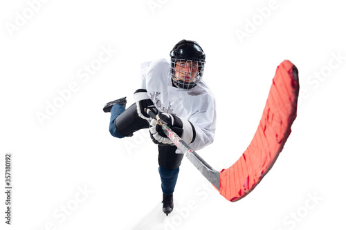 Unrecognizable male hockey player with the stick on ice court and white background. Sportsman wearing equipment and helmet practicing. Concept of sport, healthy lifestyle, motion, action. Close up.