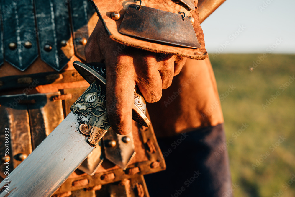 mongolian warrior holding sword in the sunset mongolian warrior holding sword in the sunset