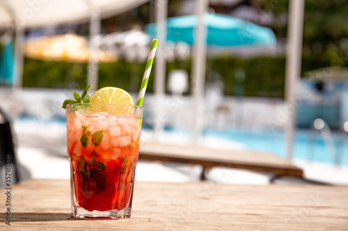 tasty fresh red cocktail on wooden surface in summer
