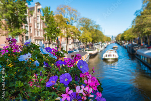 Gracht  Canal in amsterdam netherlands with boats and flowers on a bridge