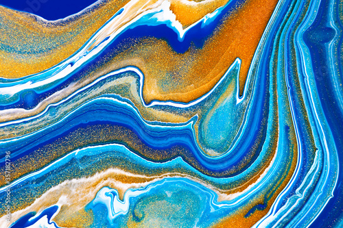 Fluid art texture. Backdrop with abstract mixing paint effect. Liquid acrylic picture that flows and splashes. Mixed paints for baner or wallpaper. Turquoise, white and golden overflowing colors