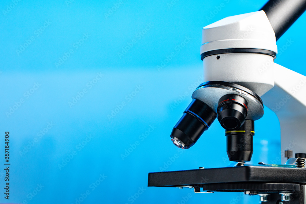 Lab microscope close up against blue background Lab microscope close up against blue background