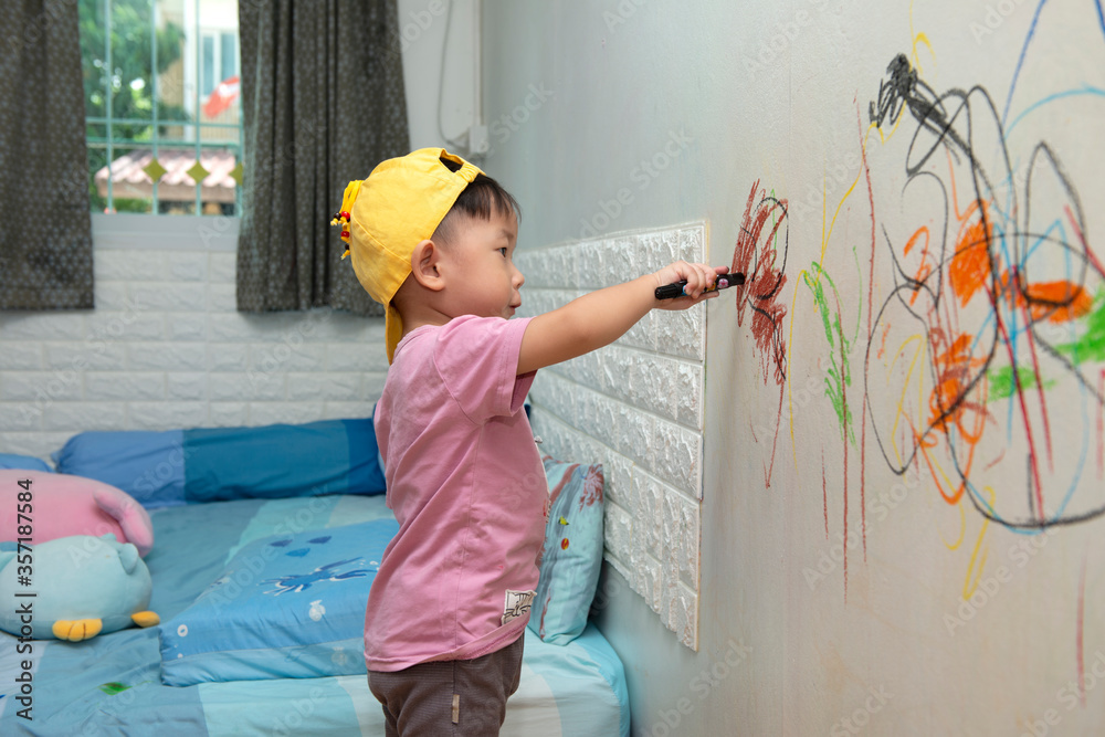 little baby boy drawing with crayon color on the wall Stock Photo ...