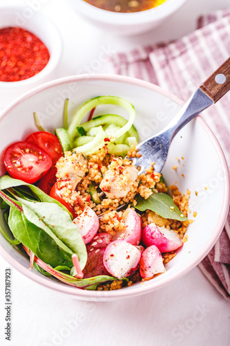 Fresh salad with couscous, tomatoes, cucumber, radish and chard.