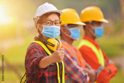 Portrait of three engineers on a construction site wearing face masks, Thailand