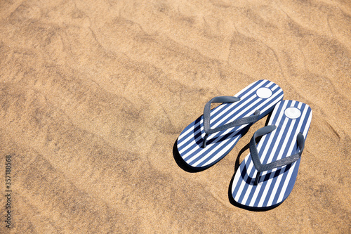 striped flip flops on sand at sunny day in Maspalomas, Gran Canaria