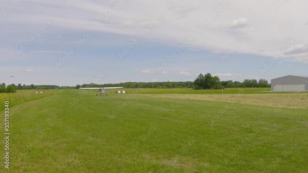 small single-engine plane travels on a green field, makes a run before takeoff, summer, green grass, the concept of small aircraft, transport small single-engine plane travels on a green field, makes a run before takeoff, summer, green grass, the concept of small aircraft, transport