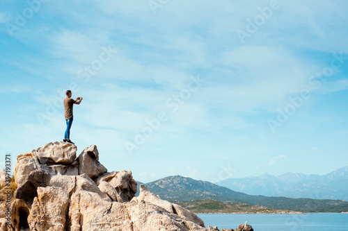 man taking a photo of the sea in Corsica, France