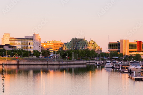 View of the Louise Basin with moored sailboats and buildings in the background during a golden hour dawn in the lower town, Quebec City, Quebec, Canada