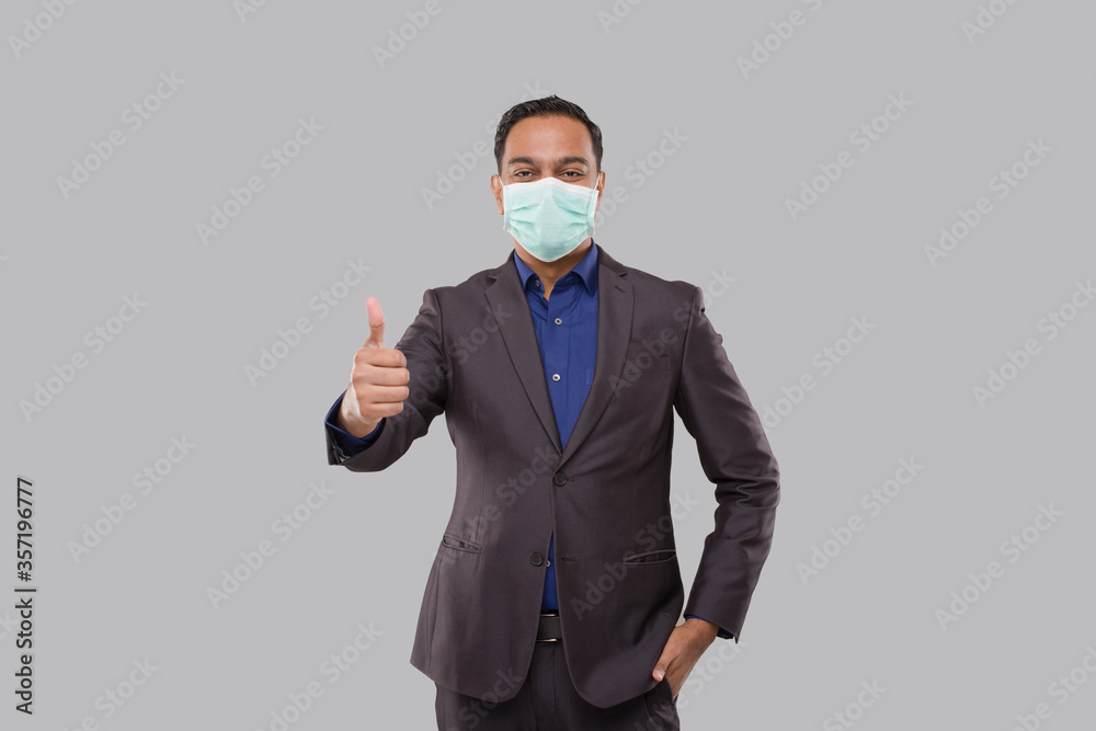 Businessman Showing Thump Up Wearing Medical Mask and Gloves Isolated. Indian Business Man Standing Thump Up sign Businessman Showing Thump Up Wearing Medical Mask and Gloves Isolated. Indian Business Man Standing Thump Up sign