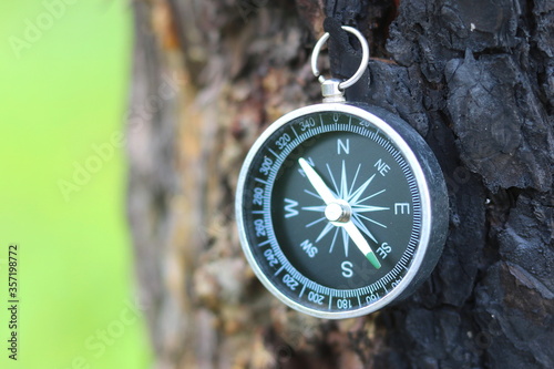 round compass on natural background as symbol of tourism, travel and outdoor activities