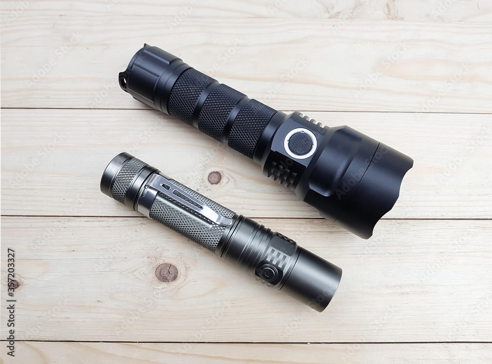Modern high power LED flashlight on wood texture background. Modern high power LED flashlight on wood texture background.