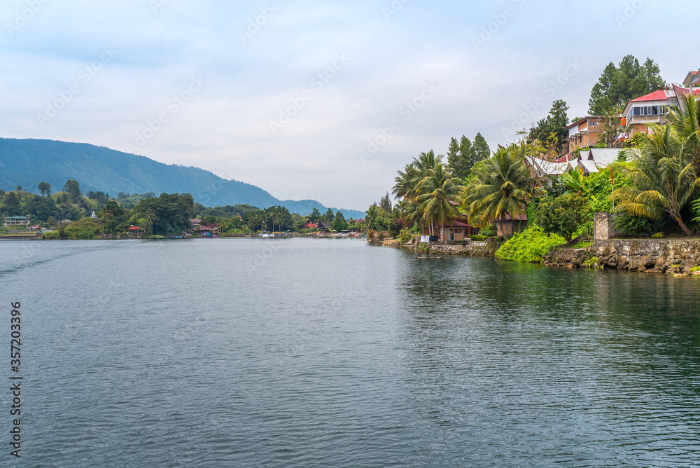Fototapeta premium The island Samosir and peninsula Tuktuk Siadong with its resorts, within the Lake Toba, the biggest volcanic lake in the world located in the middle of the northern part of the island of Sumatra 