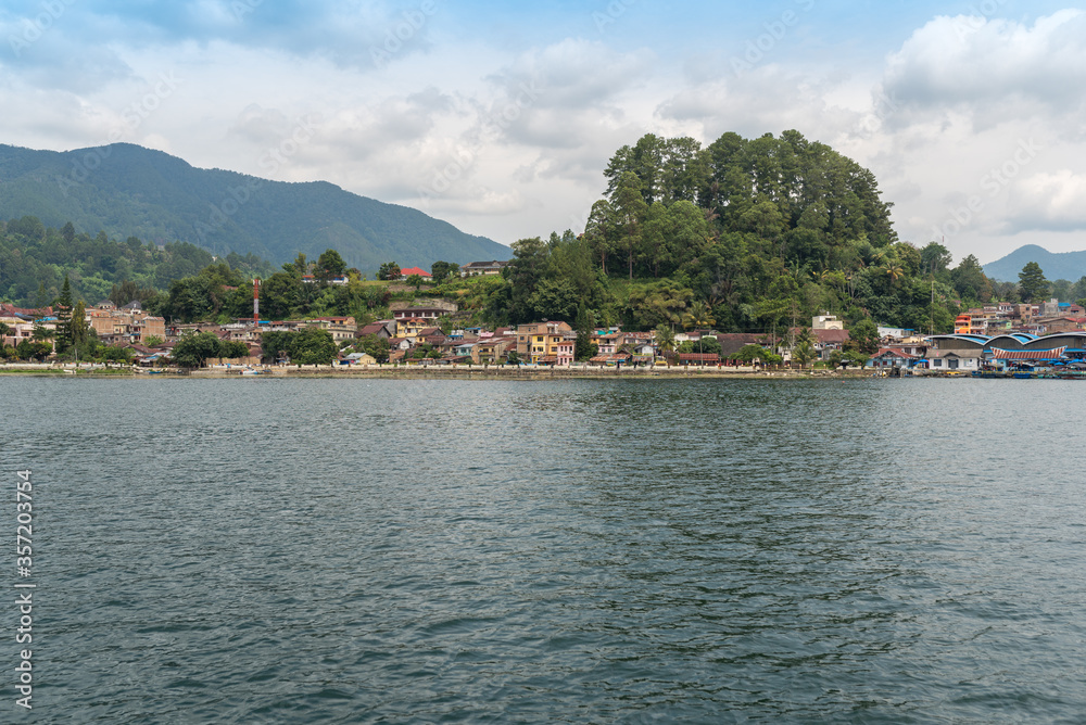 The small town Parapat with its ferry port Tiger Raja at the lakeshore of the famous Lake Toba, the largest volcanic lake in the world. The town is the ferry harbor to the island of Samosir The small town Parapat with its ferry port Tiger Raja at the lakeshore of the famous Lake Toba, the largest volcanic lake in the world. The town is the ferry harbor to the island of Samosir