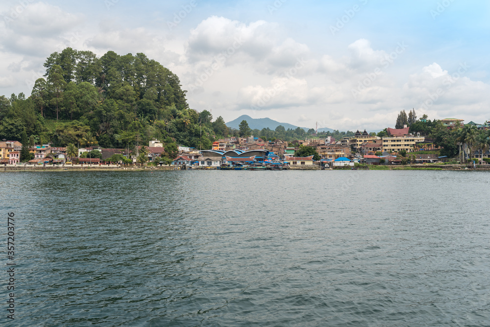 The small town Parapat with its ferry port Tiger Raja at the lakeshore of the famous Lake Toba, the largest volcanic lake in the world. The town is the ferry harbor to the island of Samosir