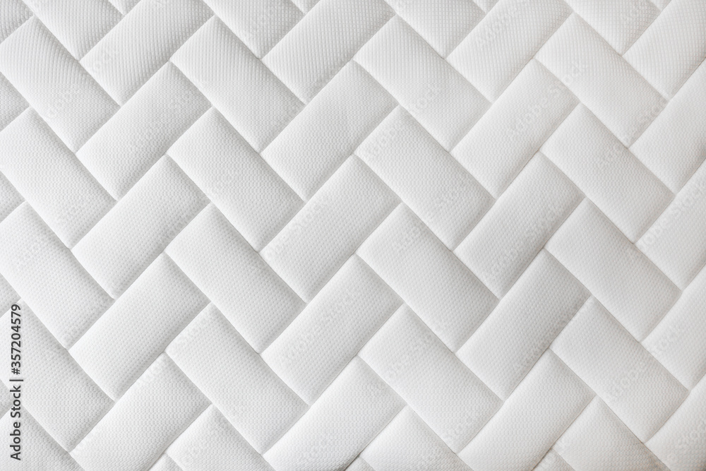 Close up shot of white orthopedic mattress top side surface pattern with a lot of copy space for text. Hypoallergenic foam matress for proper spinal alingment and pressure point relief. Background. Close up shot of white orthopedic mattress top side surface pattern with a lot of copy space for text. Hypoallergenic foam matress for proper spinal alingment and pressure point relief. Background.