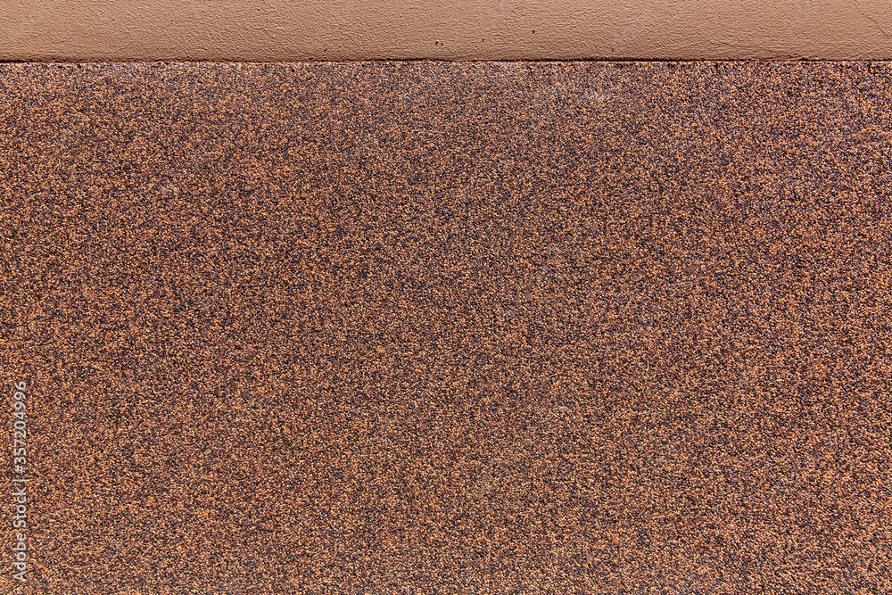 Fototapeta premium texture protective coating of the facade of the wall against moisture and water close-up of a building with a moisture resistant coating of bitumen roll with stone grain crumb, nobody.
