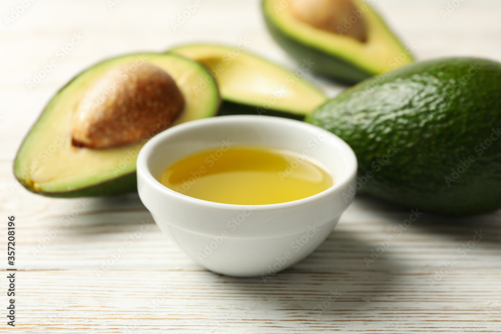 Ripe fresh avocado and oil on white wooden background, close up Ripe fresh avocado and oil on white wooden background, close up