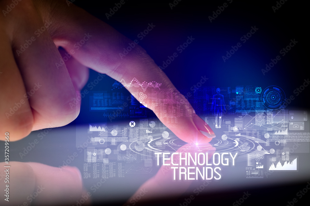 Finger touching tablet with web technology icons and TECHNOLOGY TRENDS inscription Finger touching tablet with web technology icons and TECHNOLOGY TRENDS inscription