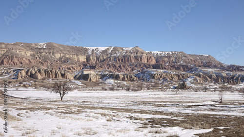 Cappadocia cone-shaped rock formations near the city of Göreme with snow during winter in central Turkey. photo