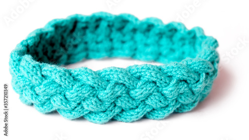 Turquoise color knitted headband with braided pattern with white background isolated