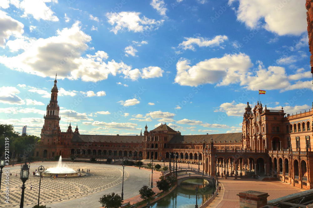 arquitectura de la plaza de España en Sevilla, con edificios, río, fuente y un cielo azul de fondo con nubes - paisaje vacío para una postal 