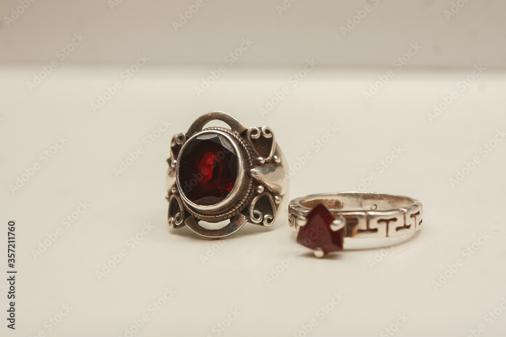 Two silver rings with natural red garnet stone on a white background. Two silver rings with natural red garnet stone on a white background.