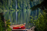 A red canoe docks at the mountain lake in Tongass National Forest  of Alaska. The lake is more than 300 feet deep. 