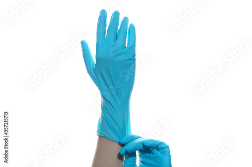 Woman hand wearing a blue rubber medical glove on white isolated background.