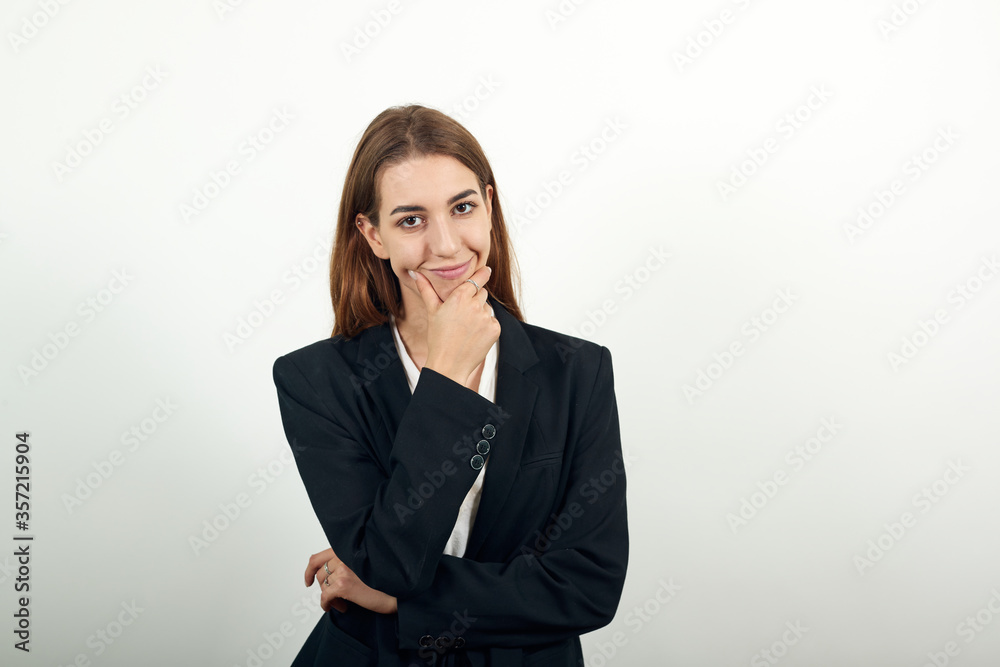 Hand on chin thinking about question, pensive expression. Doubt. Thoughtful face. Using that incredibly sharp business mind. young attractive woman with brown hair in a light t-shirt, black jacket