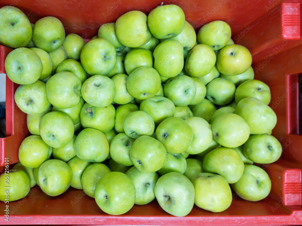 Green apples in a pallet on a counter in a self-service store. A fruit is a source of useful elements and vitamins. A healthy product in the daily diet of vegetarians and people. Green apples in a pallet on a counter in a self-service store. A fruit is a source of useful elements and vitamins. A healthy product in the daily diet of vegetarians and people.