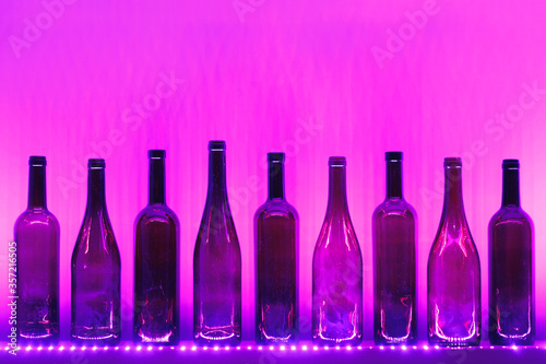 abstract empty wine bottles with purple led illumination