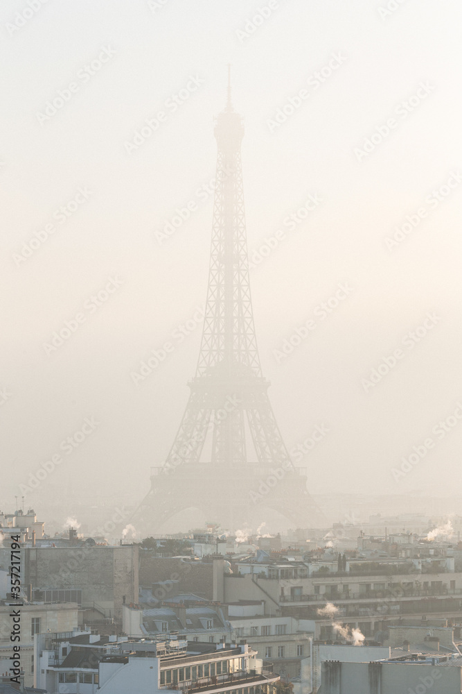 View of buildings and the Eiffel Tower in the fog / cloud of pollution during winter. December 30th, 2016. Paris, France.