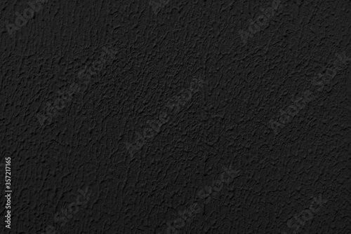 Stucco black wall of an old house. Abstract dark texture.