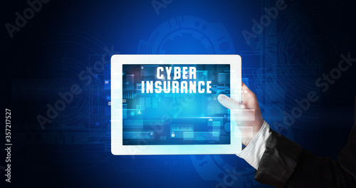 Wallpaper Mural Young business person working on tablet and shows the digital sign: CYBER INSURANCE Torontodigital.ca