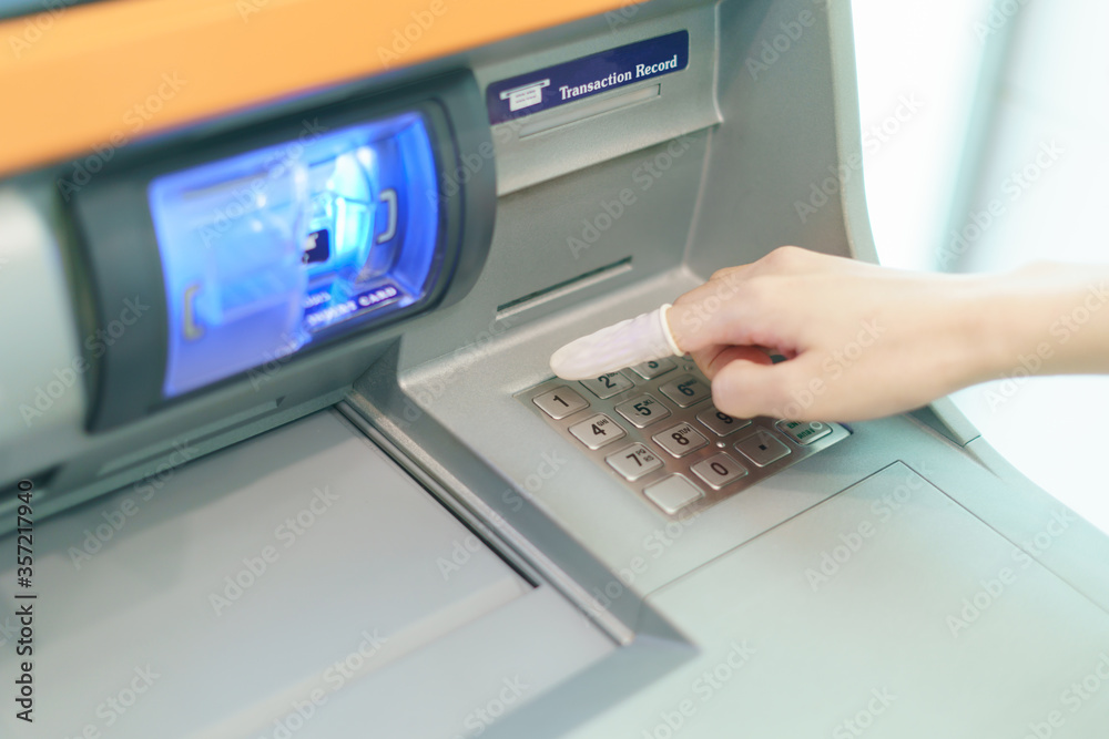 Woman wearing rubber for finger pressing a button of Automated Teller Machine( ATM ) Woman wearing rubber for finger pressing a button of Automated Teller Machine( ATM )